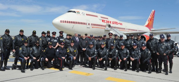 Prime MinisterNarendra Modi in a group photo with the motor cycle riders of Canada Police at the time of PM's departure from Toronto, in Canada on April 16, 2015.  Prime Minister of Canada Stephen Harper is also seen.